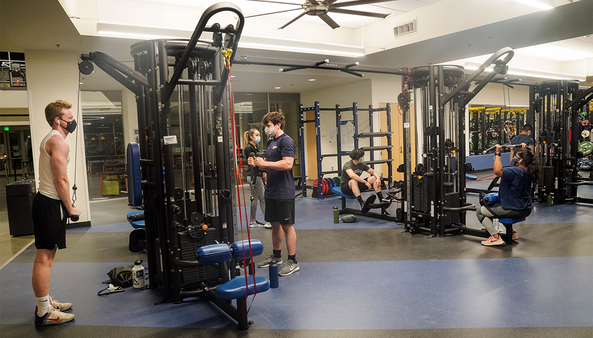 Students wearing face coverings work out at the ARC