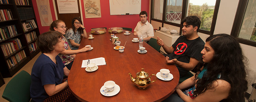 people sitting around a table drinking tea