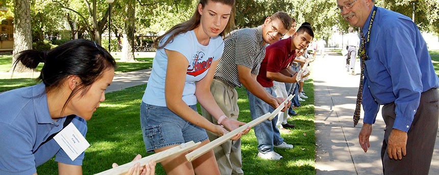 Female and male students standing in line holding boards end to end