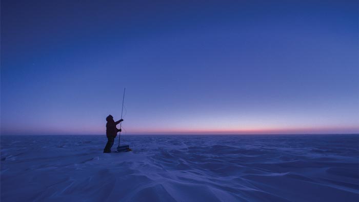 A man stands on a snowy plain