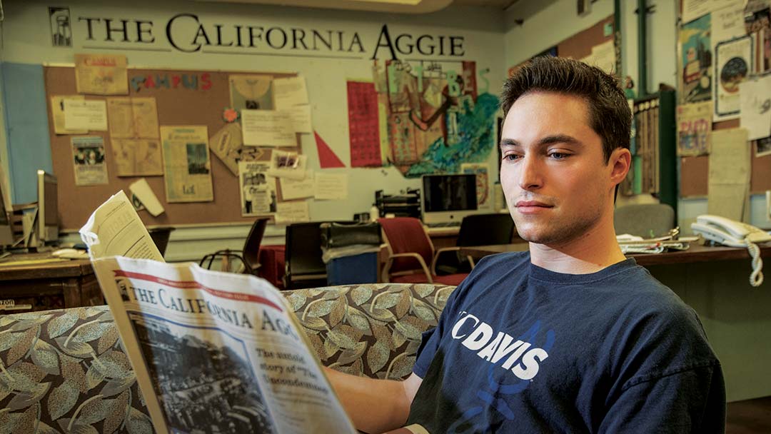 Man reading The California Aggie