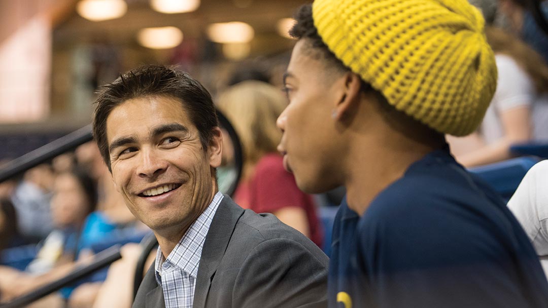 Kevin Blue talks with an athlete during a basketball game