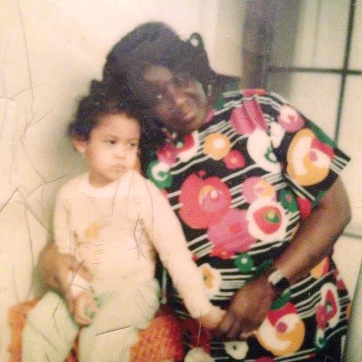 A grandmother holds a young girl on her lap