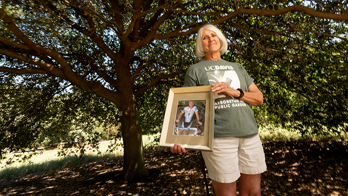 Nori Reinert holds a photo of her late husband William at the Arboretum