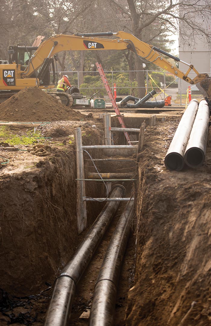 open construction trench with metal pipes laid inside