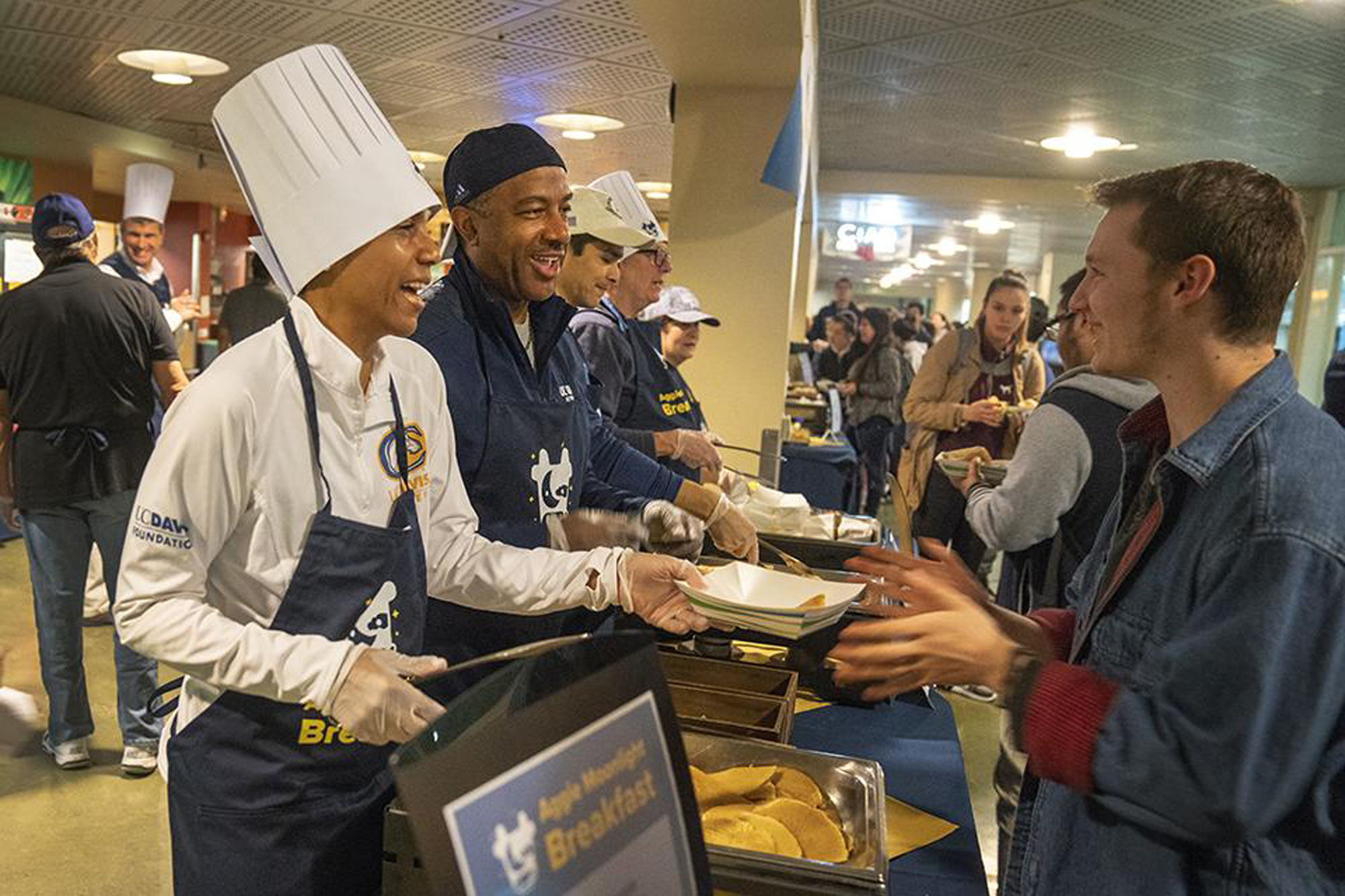 Executives in chef's attire, serving breakfast