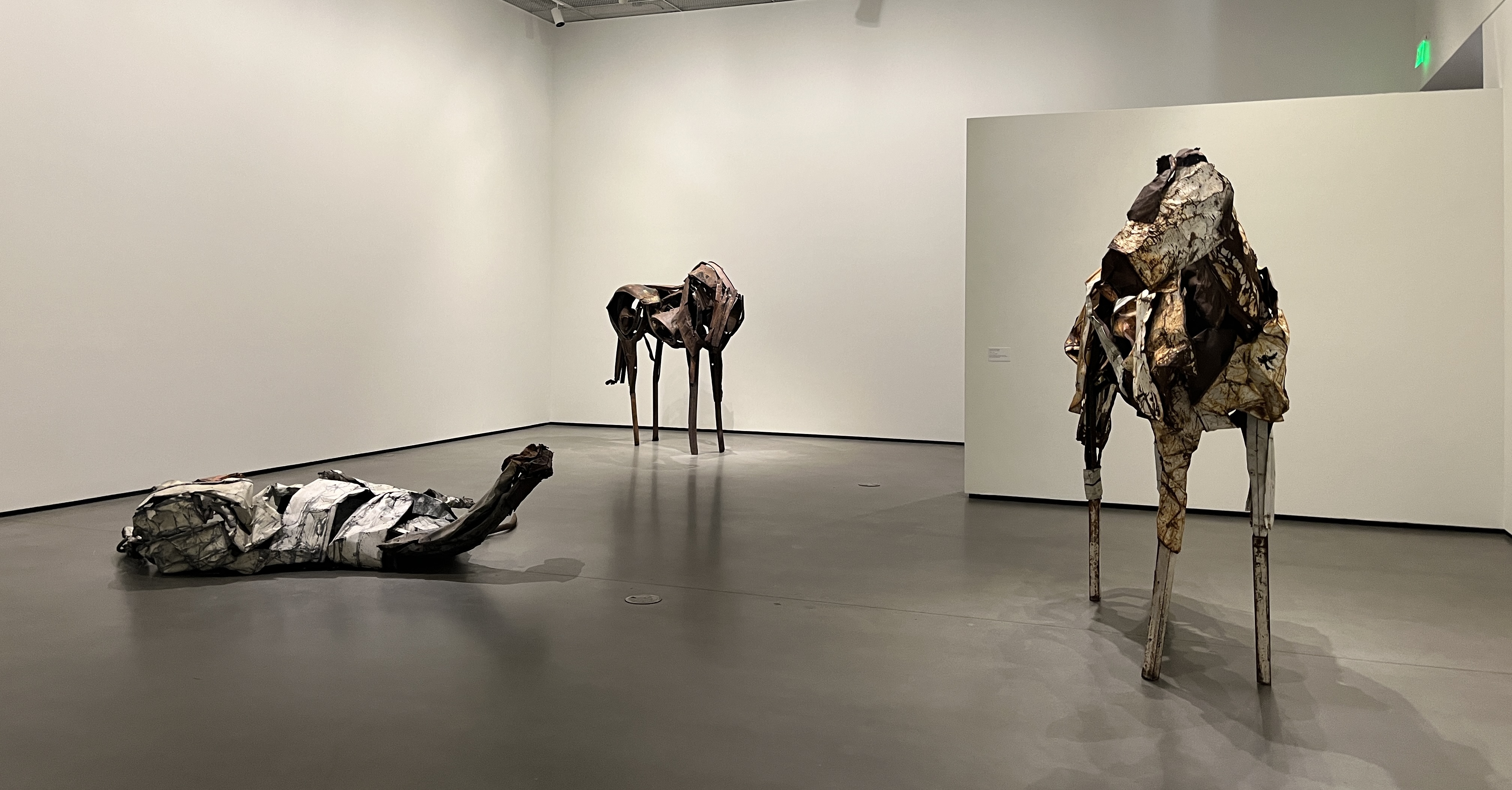 three horse scultpures in a gallery