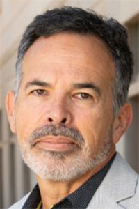 Headshot of man with salt-and-pepper beard, gray blazer, neutral expression