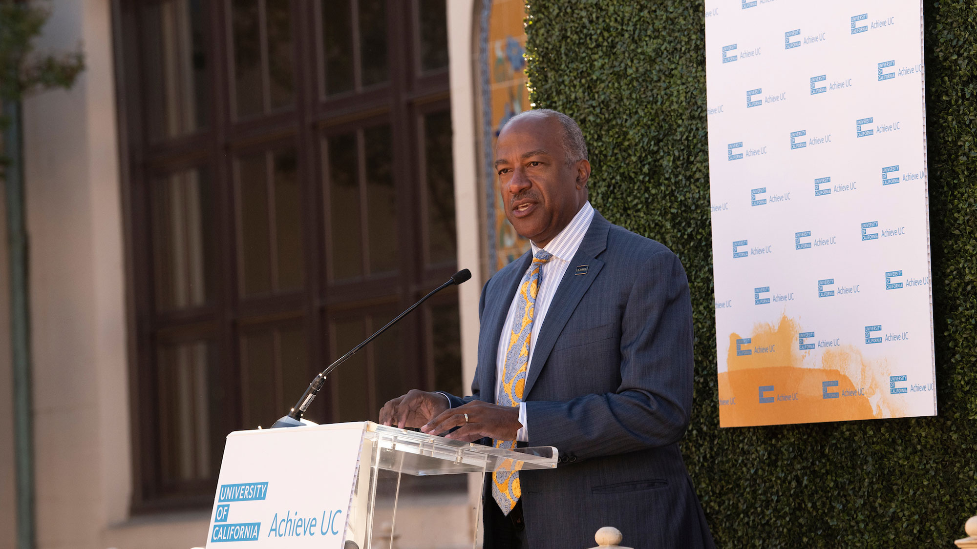 Chancellor Gary S. May at a lectern in a courtyard