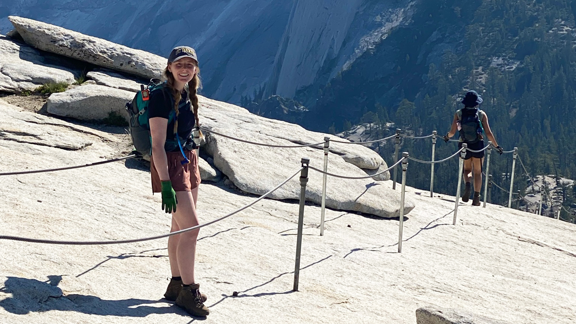 Woman stands along the cables on Half Dome in Yosemite