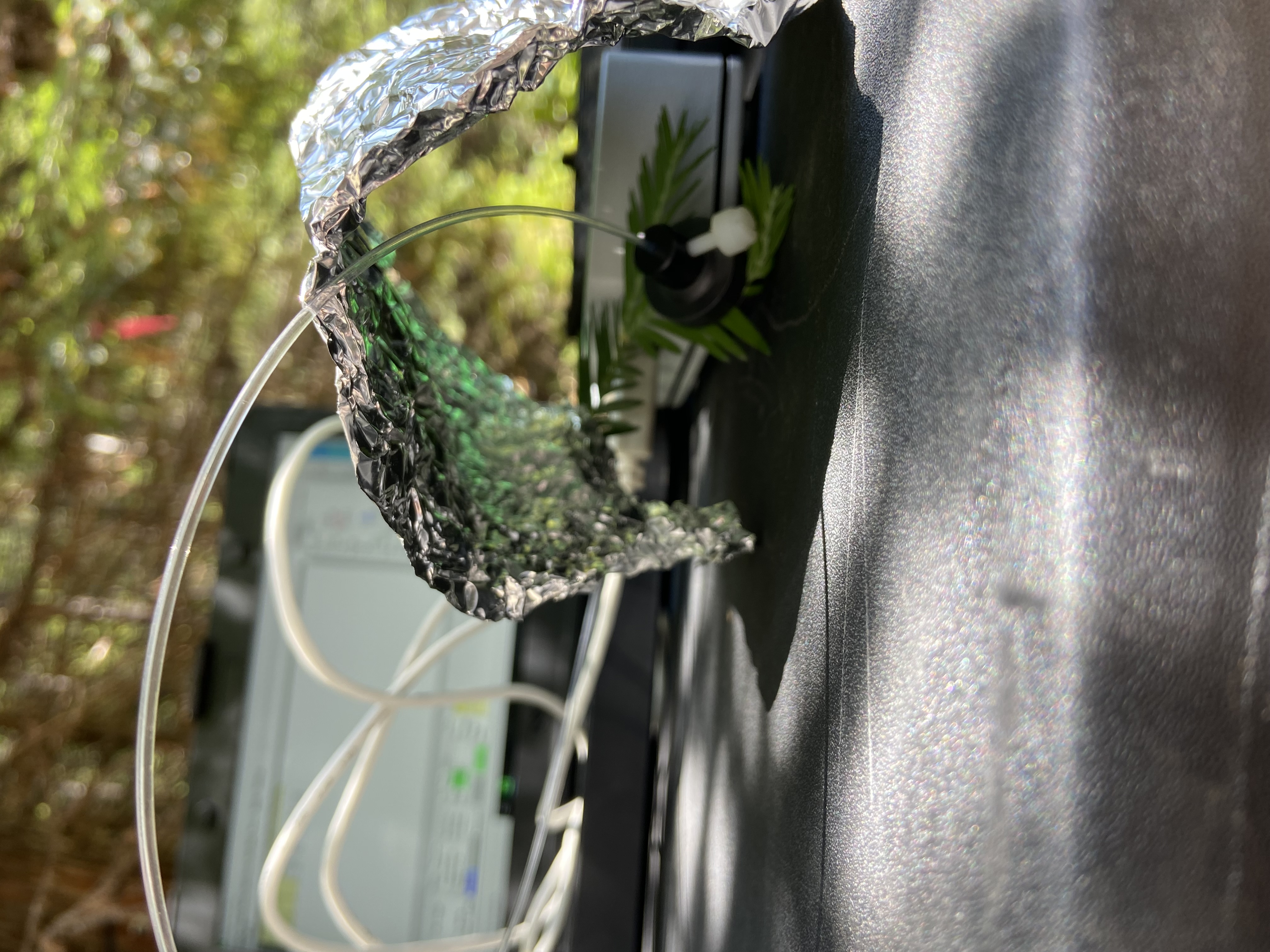 Decorative headband with silver foil, black mesh flower and green ribbon on outdoor table