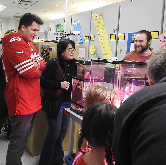 Man, woman, children peer at display