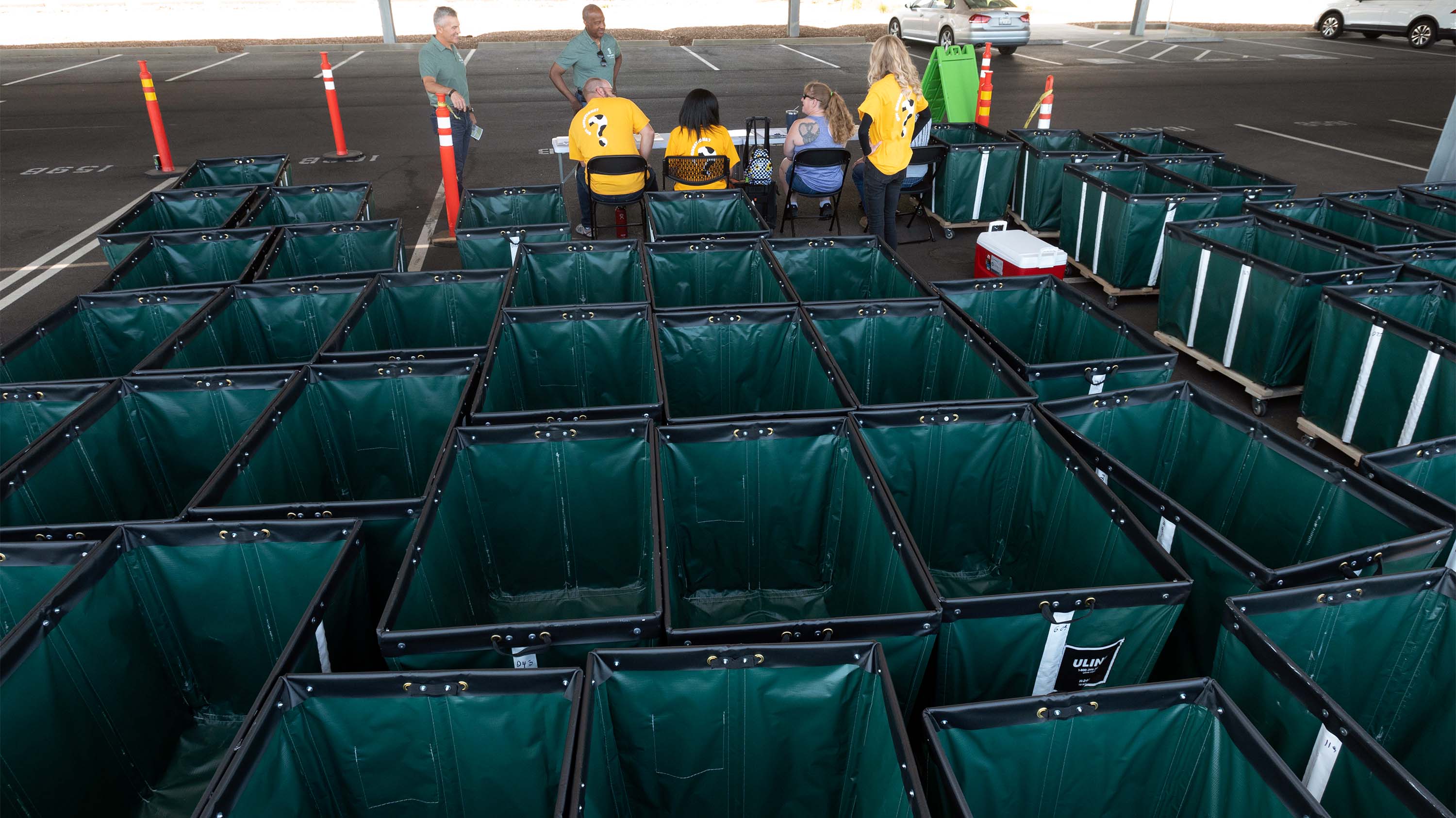 Chancellor Gary S. May and Mike Sheehan stand in front of empty moving carts.