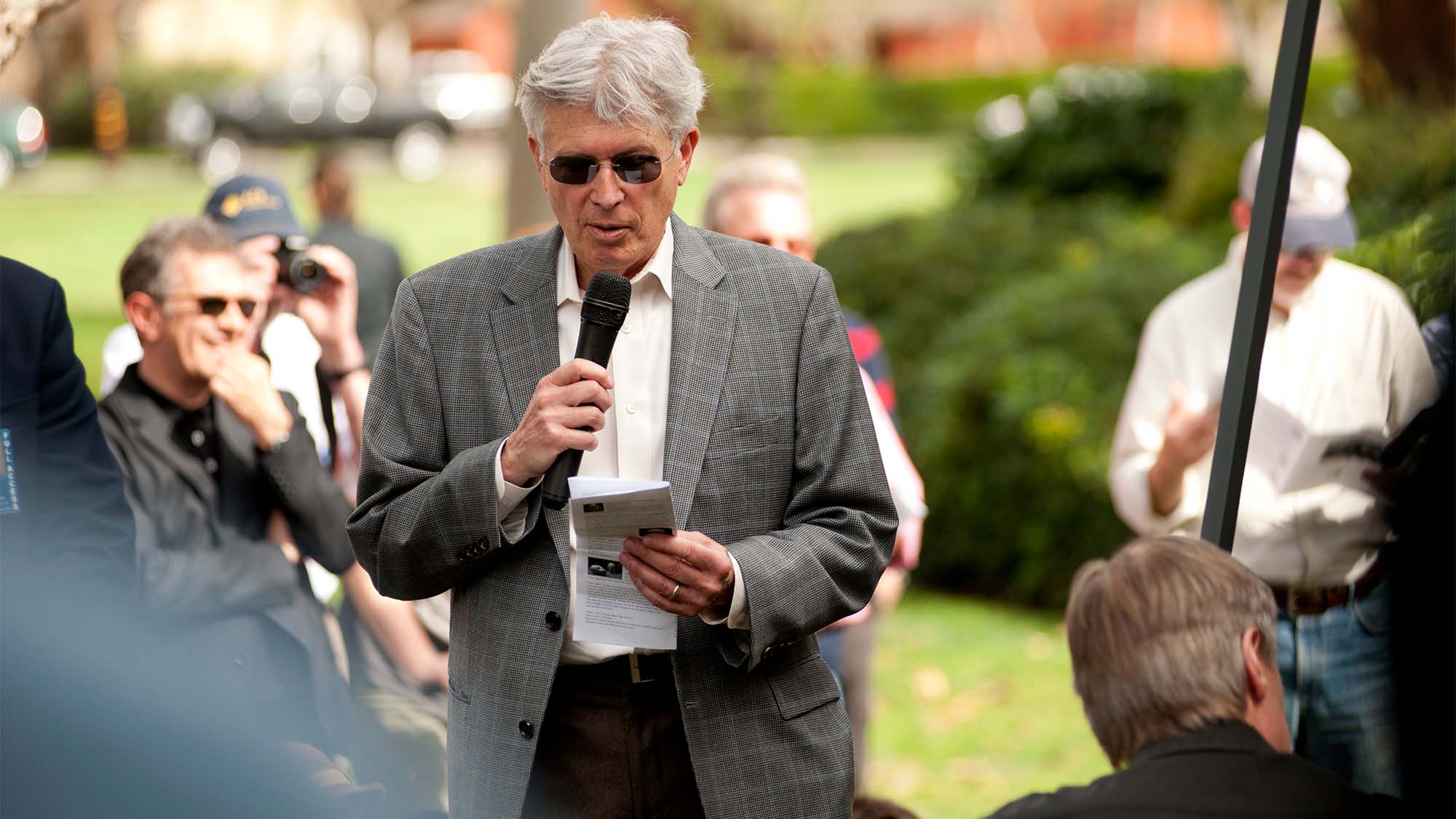 Don Roth speaks at outdoor event.