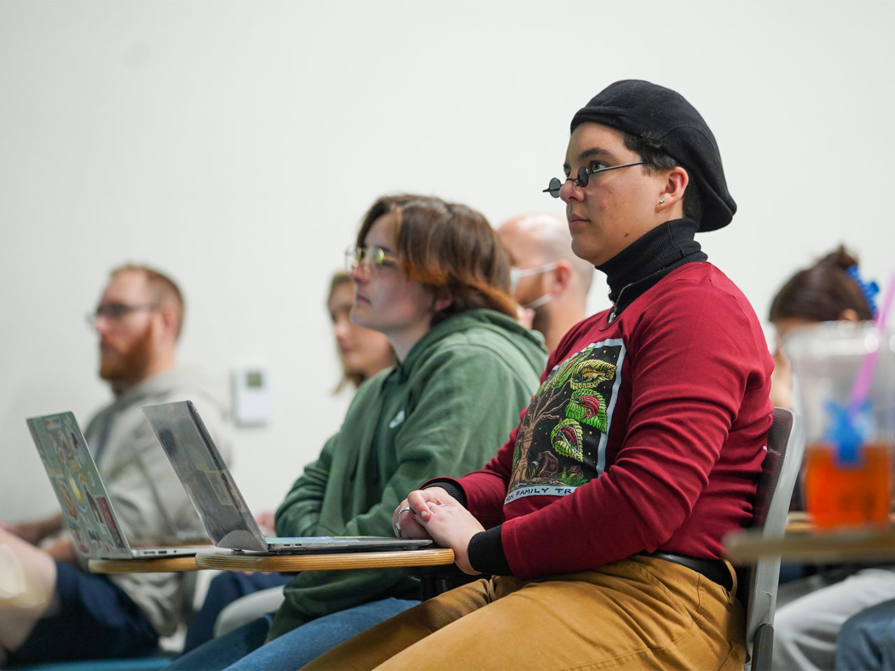 Students take notes on their laptops while listening in class.