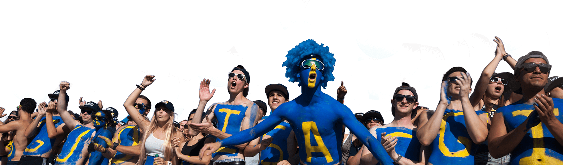 Cheering sports fans in blue and yellow, one with a blue wig and painted faces