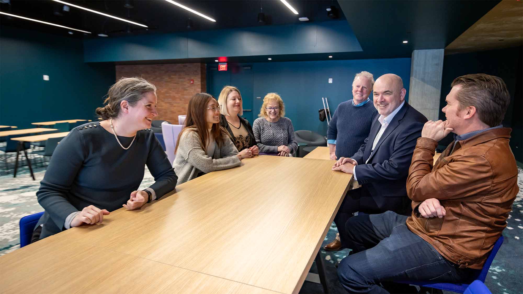 Several people sit at meeting table