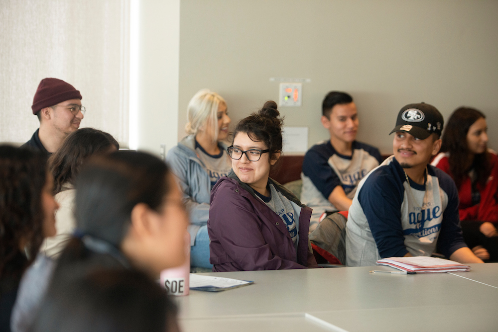 Students in a meeting smile together at UC Davis. 