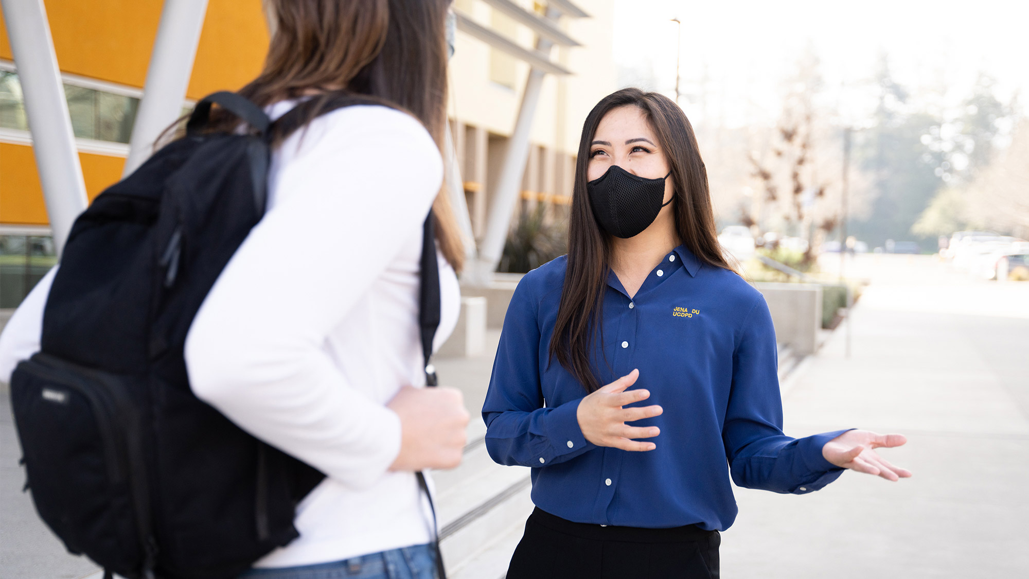 Plainclothes officer talks to student.