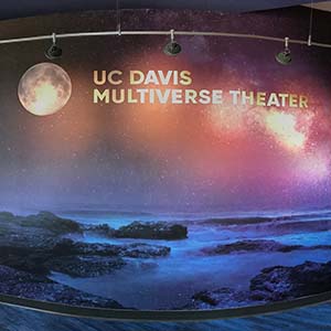 Wall decorated with images of a starry night and the words "UC Davis Multiverse Theater"