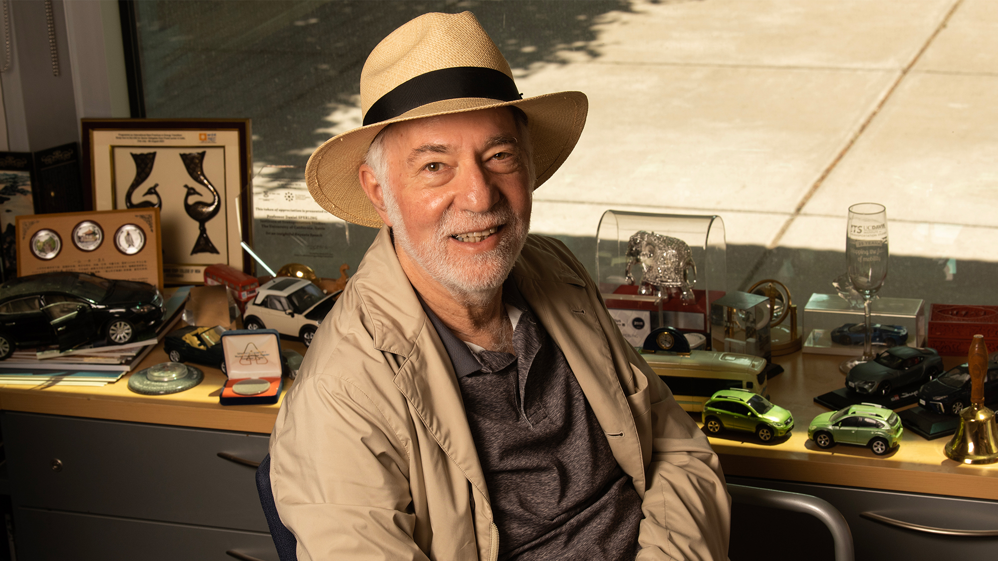 A man with a hat sitting at as desk