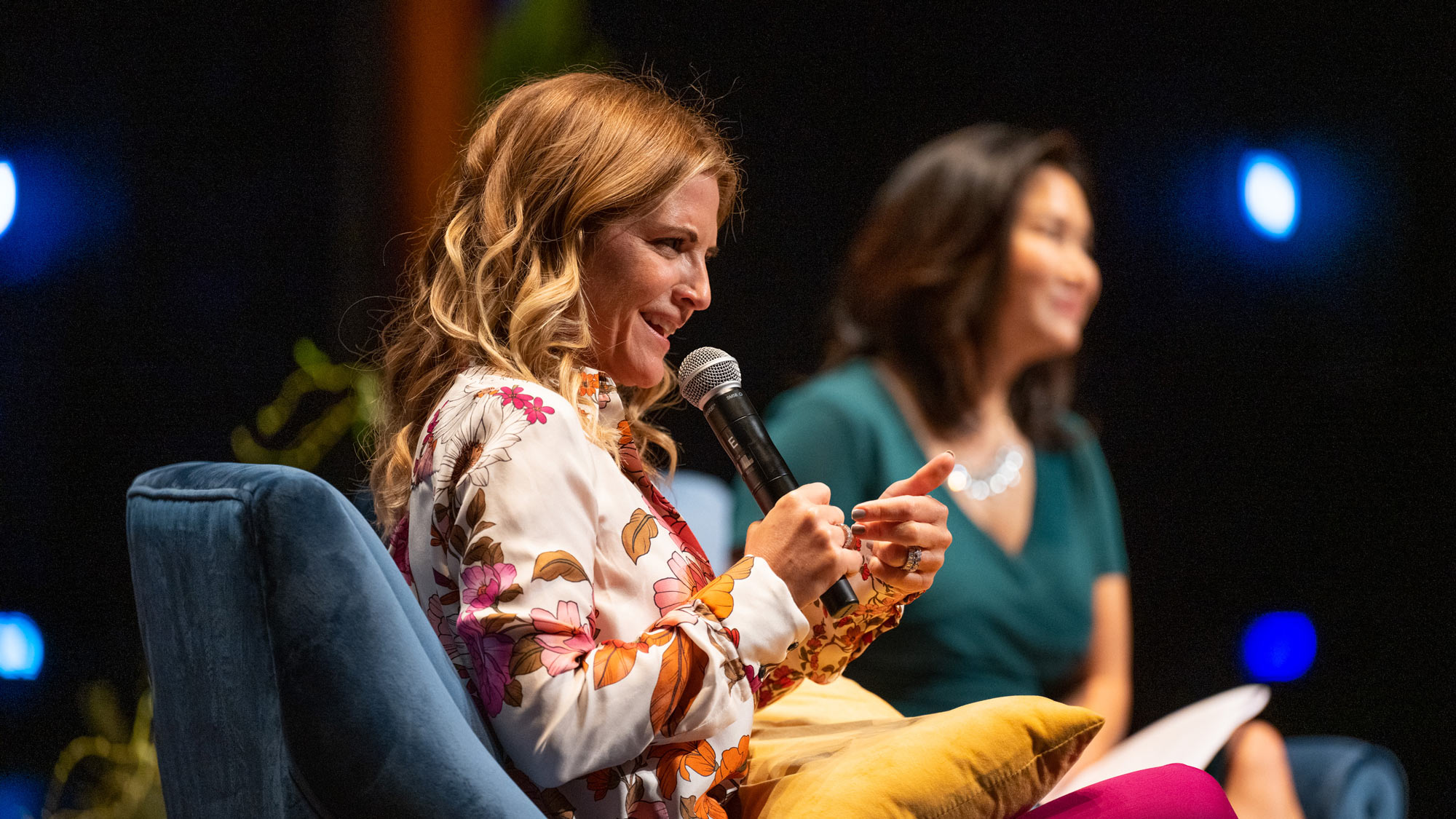 Two women, seated, onstage, in conversation