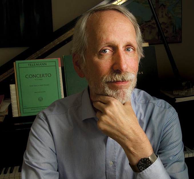 Chris Reynolds, on piano bench, facing camera