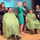 Volunteers have their hair shaved.