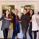 Four women stand in front of door to North Hall