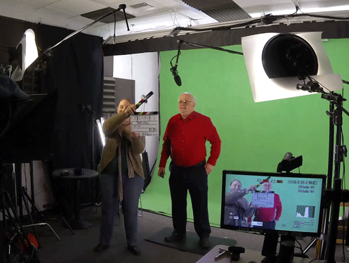 Professor in front of green scorn, for recording of online course