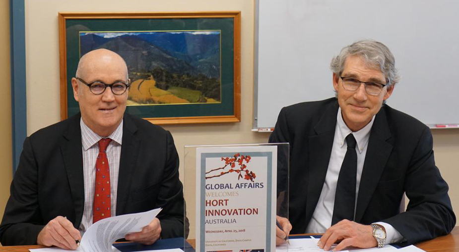 Two men at table, signing document