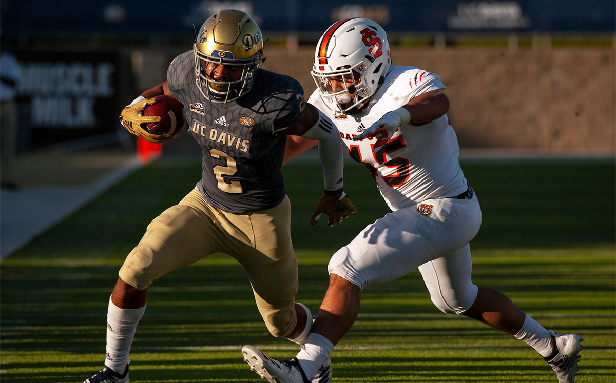 A football player runs with the ball.