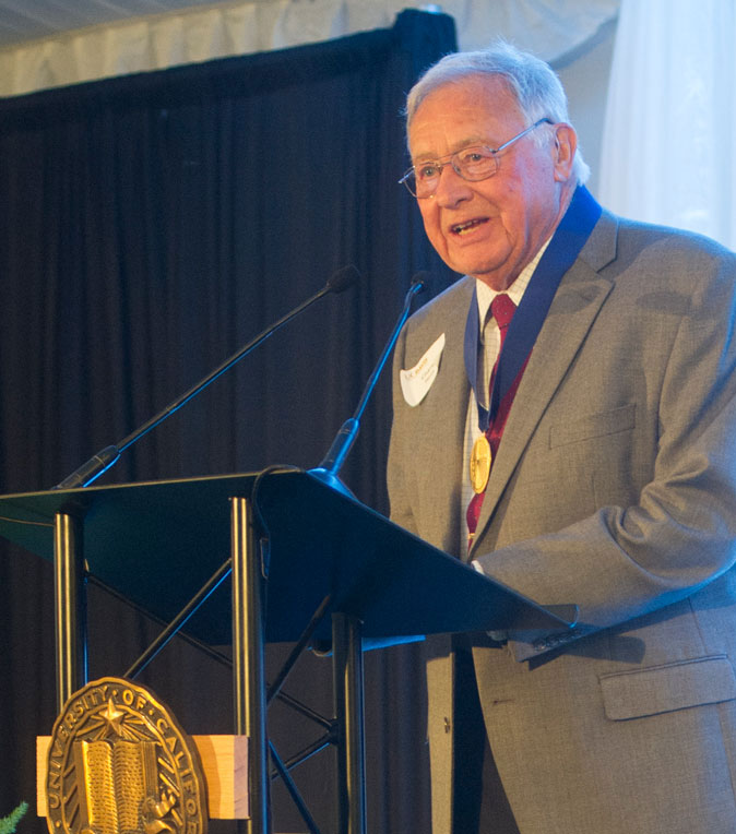 Charles E. Hess, wearing medal at podium