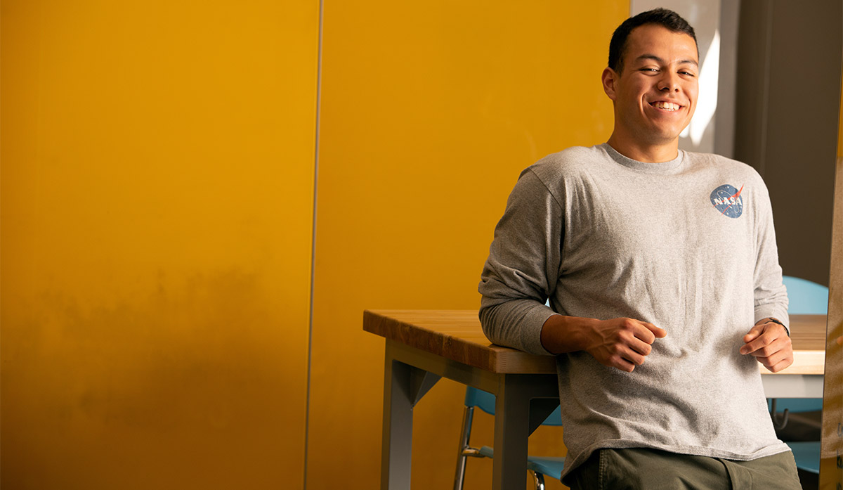 Martin Vega-Martinez sits in front of an orange wall.