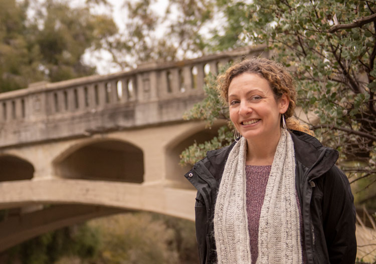 Christina De Martini Reyes poses under old bridge.