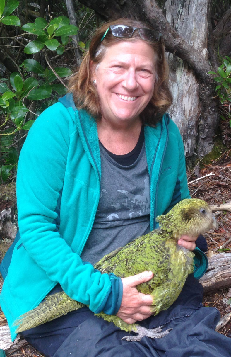 Veterinarian seated, holding parrot.