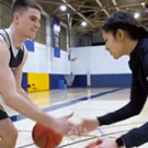 Basketball players talk and dribble with each other.