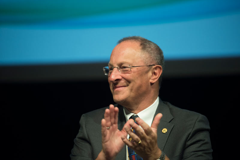 Ralph J. Hexter, smiling, applauds at Fall Convocation.