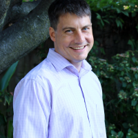 A photo of Paul Eastwick standing in front of a tree.