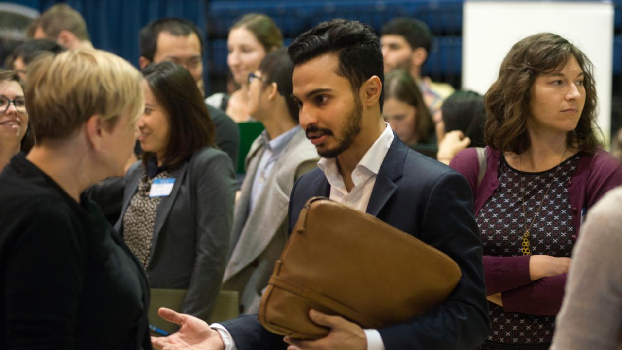 Impress at career fairs: Fahad Jan talks with company representives during the graduate career fair.