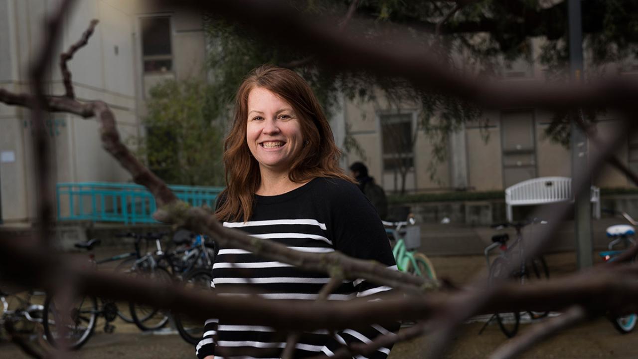 Environmental portrait of Amy Lowrey behind a tree branch
