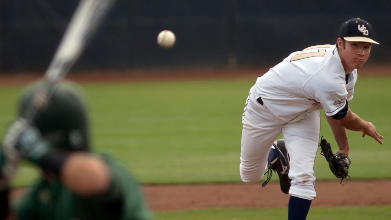 Baseball player pitching to hitter in foreground