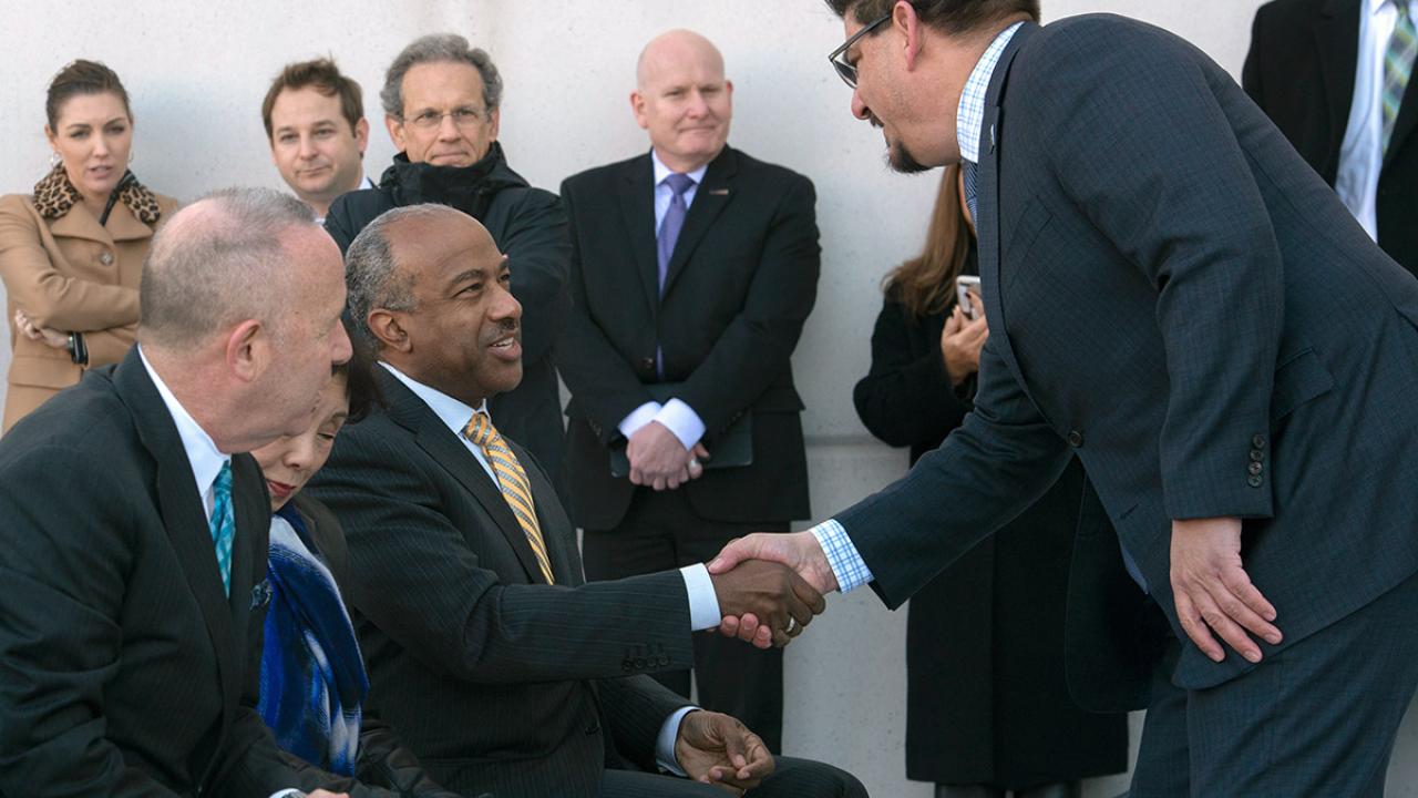 Chancellor Gary S. May shakes the hand of Phil Serna.