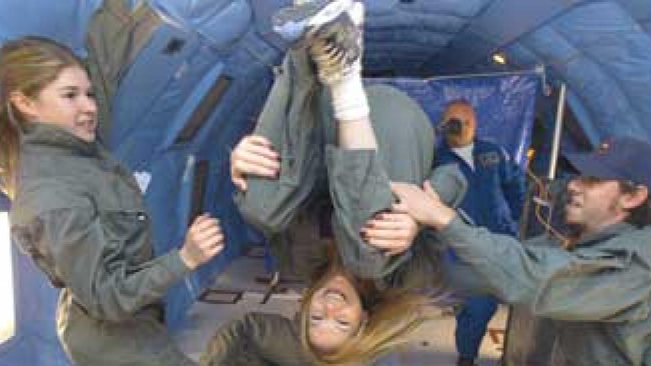 Photo: Students float in various positions in the reduced-gravity chamber.