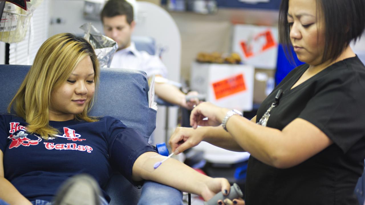 Abby Lee prepares to draw blood from Jennifer Truong.