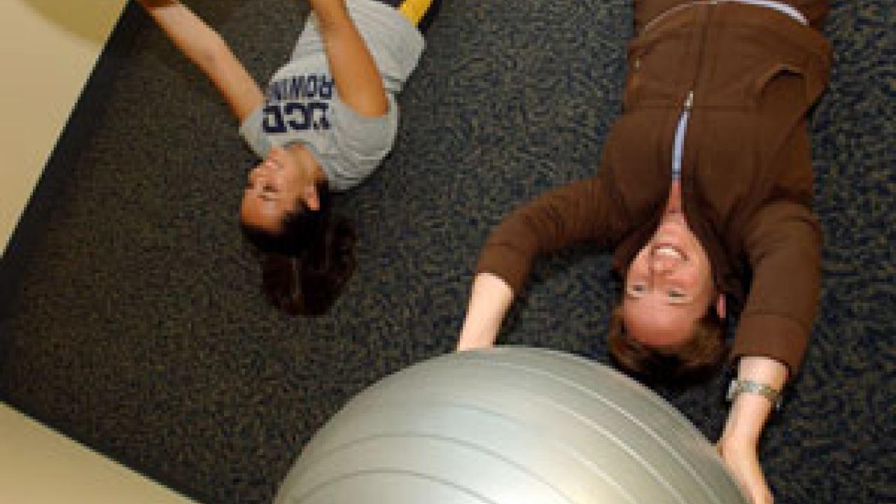 New ARC Wellness Manager Raychel Adler, right, takes UC Davis rowing team   member Joan Silva through some exercises.   