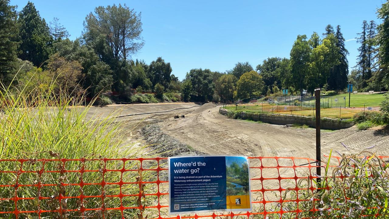 A dry lake with a fence around it