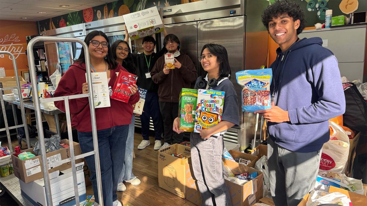 People hold up nonperishable food items in the ASUCD Pantry