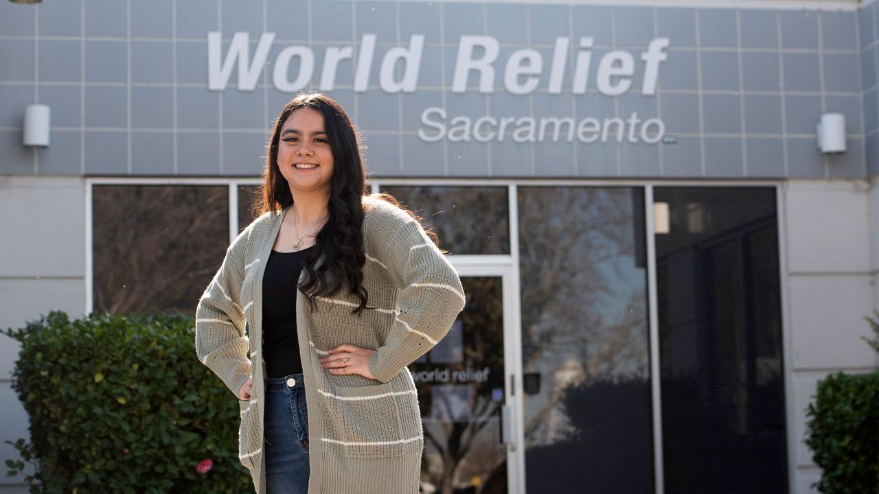 Female student stands in front of World Relief offices