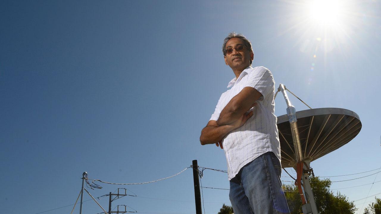 A UC Davis professor posing in front of a next generation solar collector